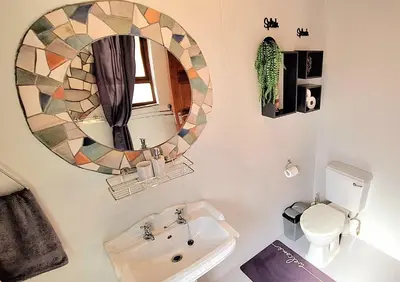 a bathroom with a mirror and a toilet and a sink at Stay at Fairway in Centurion