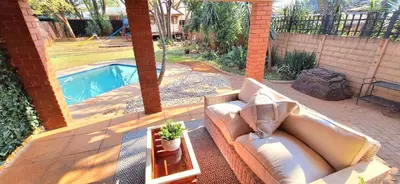 a couch sitting on a patio next to a pool at Stay at Fairway in Centurion