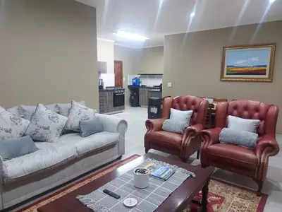 a living room with a couch and two chairs at Lloyds - 9 in Ermelo