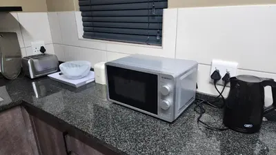 a microwave sitting on top of a kitchen counter at Lloyds - 9 in Ermelo