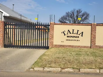 a sign on a building with a gate at Lloyds - 9 in Ermelo