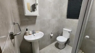a small bathroom with a toilet and a sink at Lloyds - 9 in Ermelo