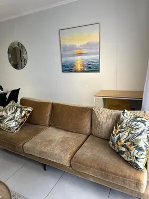 a brown couch in a living room with a painting at Luna luxury apartment in Midrand
