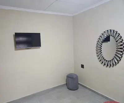a mirror on a wall in a room with a stool at Buffalo guest lodge in Bushbuckridge