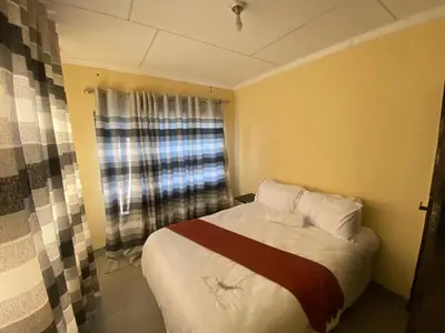 a small bedroom with a bed and a window at Buffalo guest lodge in Bushbuckridge