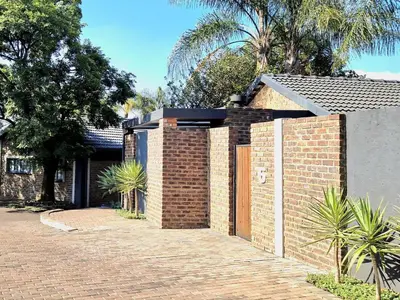 a brick wall with a gate in front of a house at Menlyn View Unit 6 in Pretoria