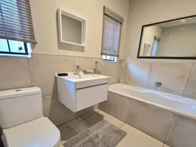 a bathroom with a toilet and a sink and a tub at Menlyn View Unit 6 in Pretoria