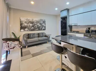 a kitchen and living room with a couch and a table at Menlyn View Unit 6 in Pretoria
