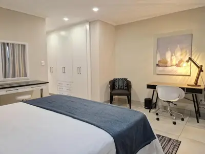 a bedroom with a bed and a desk and a computer at Menlyn View Unit 6 in Pretoria