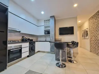 a kitchen with a counter and a sink and a stove at Menlyn View Unit 6 in Pretoria