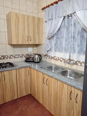 a kitchen with wooden cabinets and a sink at Yellowwood Accommodation in Polokwane