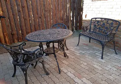 a table and two chairs sitting next to a fence at Yellowwood Accommodation in Polokwane