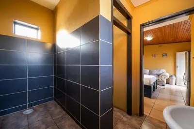 a bathroom with a sink and a mirror at De Oude Hof Lodge in Delmas
