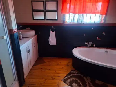 a bathroom with a bath tub and a sink at 41onLeo in Eersbewoond