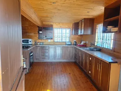 a large kitchen with wooden cabinets and wooden floors at 41onLeo in Eersbewoond