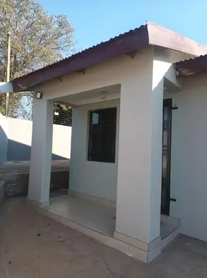 a small white building with a porch and a door at Shayas Haven in Thohoyandou