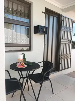 a table and chairs with a candle on a balcony at Shayas Haven in Thohoyandou