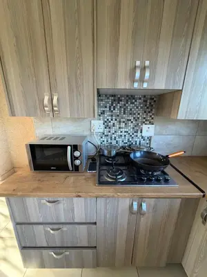 a kitchen counter with a stove and a microwave at Shayas Haven in Thohoyandou