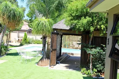 a gazebo with a table and chairs in a yard at Pool house 39 hoog in Polokwane