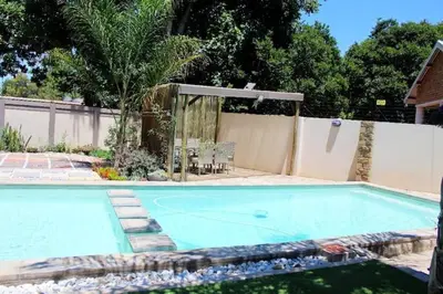 a large swimming pool in a backyard with a fence at Pool house 39 hoog in Polokwane