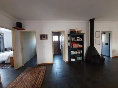 a large living room with a room with a fireplace at Graskop Cottage in Graskop