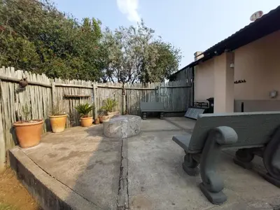 a patio with a bench and a fence at Graskop Cottage in Graskop
