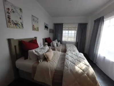 a bedroom with two beds with pillows on them at Graskop Cottage in Graskop