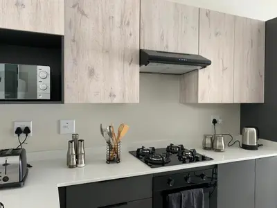 a kitchen with a stove top oven next to a microwave at Umunlád Suites in Midrand