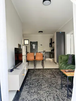 a living room with a couch and a tv at Umunlád Suites in Midrand