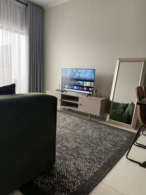 a living room with a television and a mirror at Umunlád Suites in Midrand