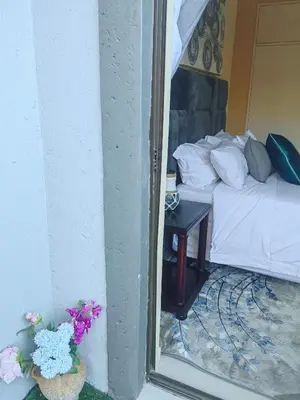 a reflection of a bedroom with a bed and a mirror at Choosers Express Boutique Hotel Room 5 in Centurion