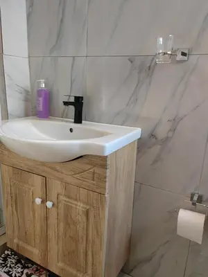 a bathroom with a white sink and marble walls at Choosers Express Boutique Hotel Room 5 in Centurion