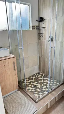 a shower with a glass door in a bathroom at Hazel Haven 1 Guest House in Pretoria