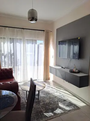 a living room with a couch and a tv at Hazel Haven 1 Guest House in Pretoria
