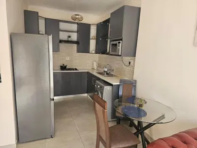 a kitchen with a table and a dining room at Hazel Haven 1 Guest House in Pretoria