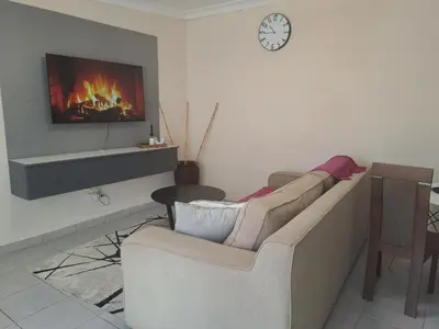 a living room with a couch and a fireplace at Hazel Haven 1 Guest House in Pretoria