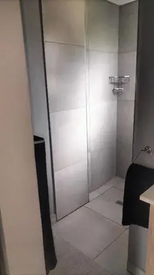 a shower with a glass door in a room at J & M Elegant Escape in Centurion