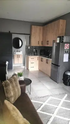 a kitchen with a stainless steel refrigerator and wooden cabinets at J & M Elegant Escape in Centurion