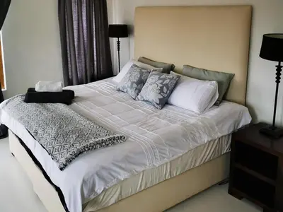 a bed with white sheets and pillows in a bedroom at Troutmere in Belfast