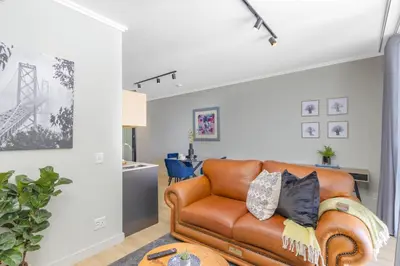 a living room with a brown leather couch at Exclusive Apartment, Ellipse in Midrand