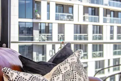 a pile of pillows sitting on a couch in front of a window at Exclusive Apartment, Ellipse in Midrand