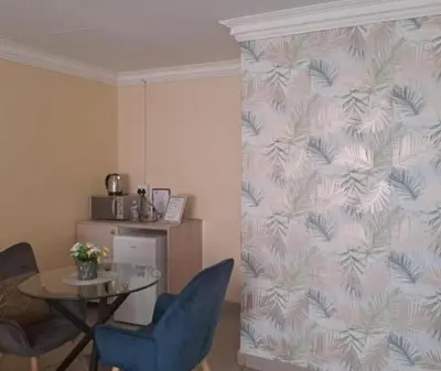 a dining room with a table and chairs and a wall at Glamour C-rane lodge in Phalaborwa