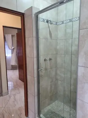 a shower with a glass door in a bathroom at Leetong Holiday Home in Hazyview