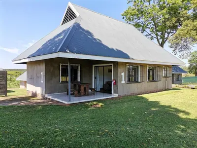 a small house with a gambrel roof on a yard at Levubu Junction Lodge in Louis Trichardt