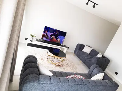 a living room with two couches and a tv at The Blyde Crystal Lagoon Penthouse in Avondzon