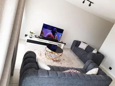 a living room with two couches and a tv at The Blyde Crystal Lagoon Penthouse in Avondzon