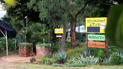 a sign for a restaurant in a garden at The Seed Pod Guesthouse in Modimolle