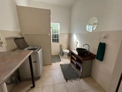 a bathroom with a sink and a toilet and a mirror at The Seed Pod Guesthouse in Modimolle