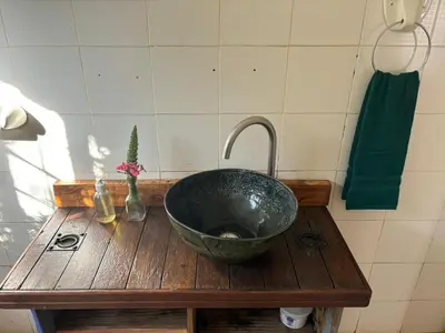 a bathroom sink with a bowl on a wooden table at The Seed Pod Guesthouse in Modimolle