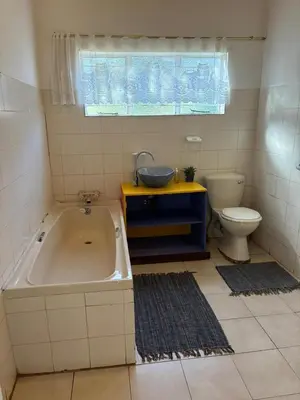a bathroom with a tub and a sink and a toilet at The Seed Pod Guesthouse in Modimolle